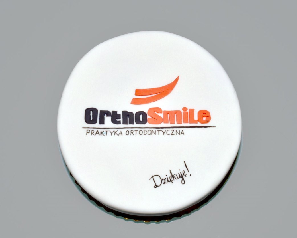Praktyka Ortodontyczna Orthosmile, Wrocław. Zdjęcie tortu od wdzięcznej pacjentki po zakończeniu 3‑letniego leczenia.